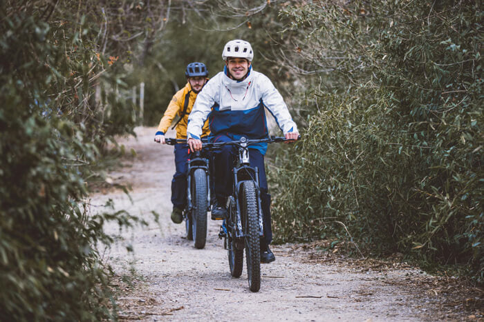 two men riding bicycles on a trail