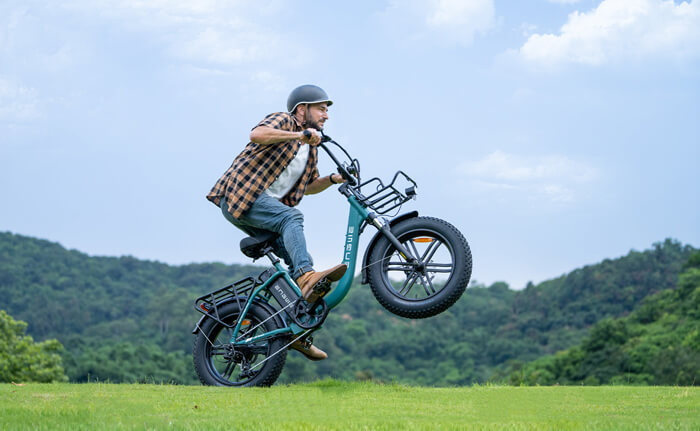 a man rides a powerful engwe l20 boost e-bike on the grass