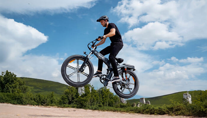 a man riding an engwe x26 electric bike on the sand