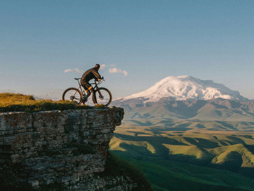 a man riding a bicycle on cliff