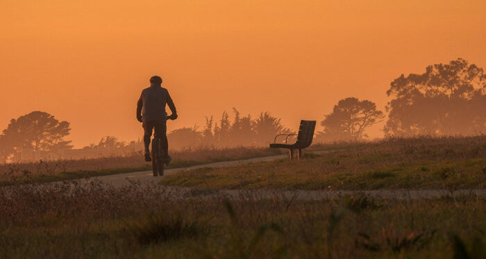 a man rides a bike at dusk