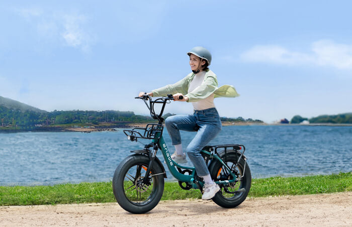 a woman wearing a helmet rides an engwe l20 boost on the road