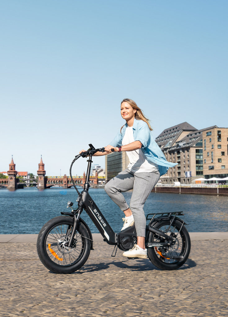 a woman riding a black engwe l20 3.0 pro collapsible e bike on the road