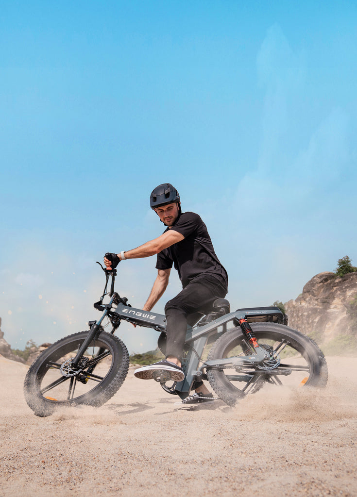 a man rides an engwe x26 e-bike on the sand